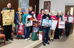 Father Stephen Giannini, pastor of St. Martin of Tours Parish in Martinsville, left, joins members of the parish&rsquo;s Altar Society as they pose for a photo with their Christmas gifts for local nursing home residents and families from the Martinsville community.  (Submitted photo)