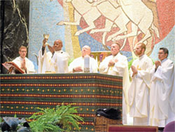 Marianhill Father Jean Bosco Ntawugashira elevates a chalice during a Nov. 3 Mass at St. Rita Church in Indianapolis honoring St. Martin de Porres, a patron saint of racial justice. Joining him as concelebrants at the Mass are, from left, Father Jack Wright, Father John McCaslin, Father Michael O&rsquo;Mara, Father Vincent Gilmore and Father Jose Neri. (Photo by Sean Gallagher)