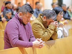 C&eacute;sar, a la izquierda, Julio y Margarita Z&uacute;&ntilde;iga se arrodillan en oraci&oacute;n durante una misa celebrada el 3 de noviembre en la Iglesia de Santa Rita de Indian&aacute;polis en honor a San Mart&iacute;n de Porres, patr&oacute;n de la justicia racial. (Fotograf&iacute;a de Sean Gallagher)