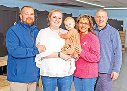 Jordan and Gabrielle Bullard, left, smile with their baby, Lynne Marie, together with Monica Kelsey, founder of Safe Haven Baby Boxes (SHBB), and her husband Joe in Woodburn, Ind., during the opening of SHBB&rsquo;s new baby box production facility on Dec. 2, 2023. The Bullards adopted Lynne a month after she was surrendered in a Safe Haven Baby Box in Indiana in February 2023. (Submitted photo by Jason Mann of J Michael Photography, LLC)