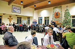 Young men from across the archdiocese listen on Dec. 28 to Father Michael Keucher, archdiocesan vocations director, speak about priestly vocations during the archdiocesan vocations office&rsquo;s annual St. Andrew Dinner at Bishop Simon Brut&eacute; College Seminary in Indianapolis. (Photo by Sean Gallagher)