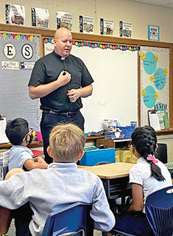 Father Timothy Wyciskalla, pastor of St. Mark the Evangelist Parish in indianapolis, often visits with students at the parish&rsquo;s school to share stories and lessons about the Catholic faith. (Submitted photo)