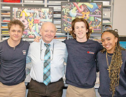 The connection between Mark Stratton, the visual arts teacher at Roncalli High School in Indianapolis, and his students shows in the smiles shared with Elyas Williams, left, Alex Plahitko and Carrianne Sabina. Stratton is this year&rsquo;s recipient of the Saint Theodora Excellence in Education Award, the highest honor given to an educator in the archdiocese. (Photo by John Shaughnessy)