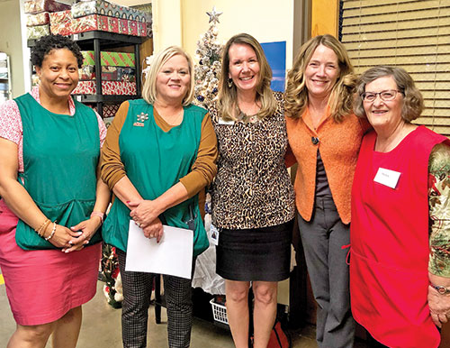 As the longtime director of the Crisis Office and the Christmas Store for Catholic Charities Indianapolis, Stephanie Davis, second from left, had a gift for surrounding herself with friends, co-workers and volunteers who shared her dedication to helping people in need. Here, she poses for a photo at the Christmas Store with Simata Wilcox, left, Cheri Bush, Eileen Dennie and Helen Burke.&nbsp; (Submitted photo)