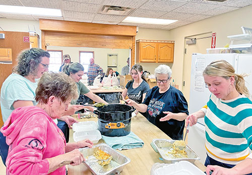 Members of St. Gabriel Parish in Connersville prepare a dinner to be shared with those in need in the local community in this photo from March 2023. While it is a charitable effort, it also serves as an opportunity to evangelize, sharing Christ&rsquo;s love and good news as the parishioners eat with those being served. (Submitted photo)