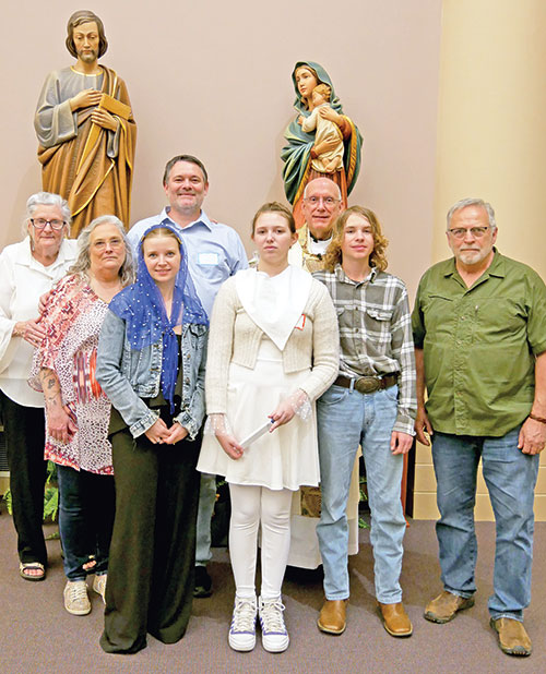 The McClain family members pose with Father Stephen Giannini, pastor of SS. Francis and Clare of Assisi Parish in Greenwood, and extended family members after the Easter Vigil Mass at SS. Francis and Clare of Assisi Church on March 31. At far left is John&rsquo;s grandmother Phyllis Long, his mother Deborah Woodard, Jessie McClain, John McClain, Jewel McClain, Father Giannini, Steven McClain and John&rsquo;s stepfather Mike Woodard. (Submitted photo)