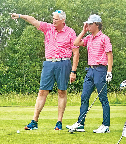 As the co-head coach of the boys&rsquo; golf program at Roncalli High School in Indianapolis, Jim Poole works closely with his team members, including giving a tip to Noah Irwin, during this past season. (Submitted photo)