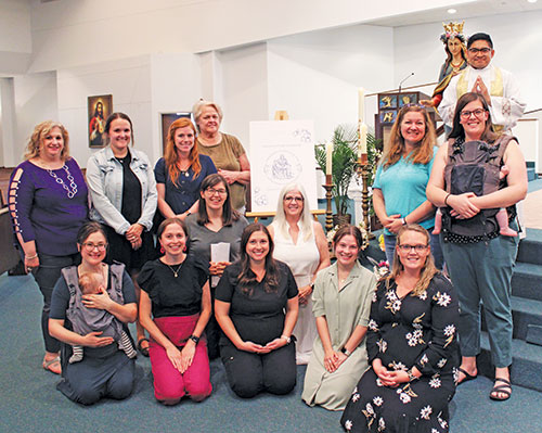 Women who restarted a local chapter of the Confraternity of Christian Mothers at Our Lady of the Greenwood Parish in Greenwood pose in the parish church on May 13 after receiving a blessing from Father Jose Neri, the parish&rsquo;s parochial vicar. (Photo by Jennifer Lindberg)