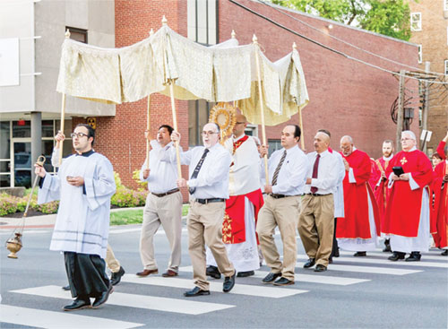 Father Michael Keucher, archdiocesan vocations director and spiritual advisor of the local Catholic Charismatic Renewal apostolic movement, processes with the Eucharist from SS. Peter and Paul Cathedral in Indianapolis to the Archbishop Edward T. O&rsquo;Meara Catholic Center after a Pentecost liturgy on May 18. (Submitted photo)