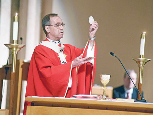 Archbishop Charles C. Thompson elevates the Eucharist during a Mass on June 29, 2020, in SS. Peter and Paul Cathedral in Indianapolis. In describing the impact of the Eucharist, the archbishop says, &ldquo;It&rsquo;s Jesus at work here in the lives of people.&rdquo;  (File photo by Sean Gallagher)