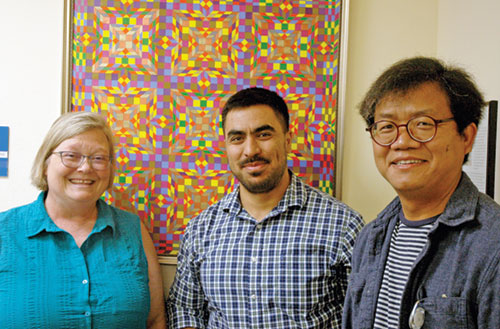 As the director of refugee services for the archdiocese&rsquo;s Catholic Charities Indianapolis, Jessica Inabnitt uses her love of the Eucharist to guide her in helping refugees from around the world make a successful transition to life in the United States. Here, she poses for a photo with two members of her staff, Ahmad Ghaznawi, center, a job placement specialist who is a refugee from Afghanistan, and Anthony Khual, a cultural orientation specialist who is originally from Myanmar. (Photo by John Shaughnessy)
