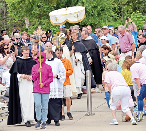People start to take to their knees in Christ&rsquo;s presence at the base of a ramp to the Louisville, Ky., side of the Big Four Bridge over the Ohio River as a eucharistic procession to Jeffersonville gets under way on July 9, marking the entrance of the National Eucharistic Pilgrimage&rsquo;s southern route into the Archdiocese of Indianapolis. (Photo by Natalie Hoefer)
