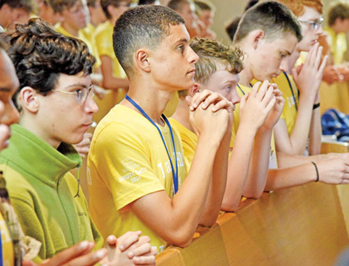 Participants in Bishop Brut&eacute; Days kneel in prayer on July 8 in St. Paul Church in New Alsace, a campus of All Saints Parish in Dearborn County, during Bishop Brut&eacute; Days, the archdiocese&rsquo;s annual vocations camp. They are, from left, Sebastian Alvarez, Aidan McKay, Joshua Fuller, Patrick Taber and Jacob Branaham. (Photo by Sean Gallagher)