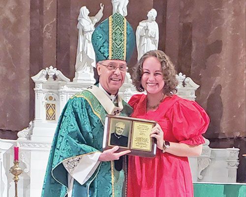 Emily Mingus, a member of St. Joan of Arc Parish in Indianapolis, beams as she receives the Archbishop O&rsquo;Meara Respect Life Award from Archbishop Charles C. Thompson during the Respect Life Mass at SS. Peter and Paul Cathedral in Indianapolis on Oct. 6. (Photo by Natalie Hoefer)