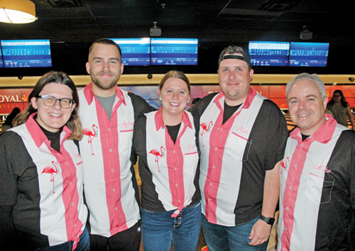 The smiles and the flamingo-designed bowling shirts that connect teammates Emily Mastronicola, left, Jeffrey Brown, Rachel Gilman, Kyle Ginty and Mike O&rsquo;Connell are striking examples of the fun and joy that marked the IndyCatholic&rsquo;s young adult bowling league this fall. (Photo by John Shaughnessy)