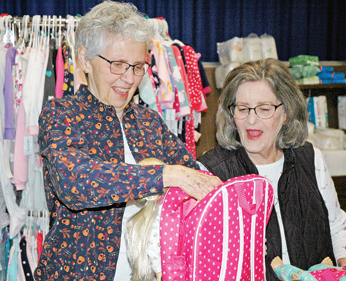 Marilyn Webb, left, and Helen Burke, volunteers at the archdiocesan Catholic Charities&rsquo; Christmas Store in Indianapolis, show their delight at the donation of a doll, knowing it will make a child&rsquo;s Christmas special. (Photo by John Shaughnessy)