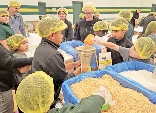 Students and staff of Holy Spirit School in Indianapolis prepare pre-packaged meals for Indianapolis-based Million Meal Movement in the school&rsquo;s gym on Nov. 19, 2024. (Submitted photo)