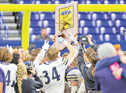 Members of the football team of Our Lady of Providence High School in Clarksville raise Indiana&rsquo;s Class 1A state championship trophy in joy after completing a perfect 14-0 season when they defeated the team from North Judson High School 35-20 on Nov. 30. (Submitted photo)