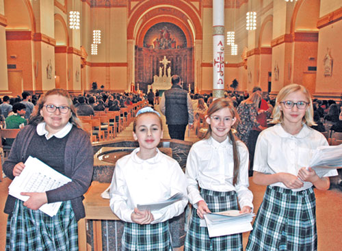 Before the archdiocese&rsquo;s Catholic Schools Week Mass at SS. Peter and Paul Cathedral in Indianapolis on Jan. 29, a group of sixth-grade students handed out worship aids to participants. Leanna Paul, left, of St. Gabriel School in Connersville joined three students from St. Mary School in Rushville: Maria Mosburg, left, Hadley Burklow and Kallie Gettinger. (Photo by John Shaughnessy)