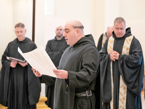 Benedictine Brother Gregory Morris reads on Jan. 25 from the hand-written document of his solemn vows as a monk of
Saint Meinrad Archabbey in St. Meinrad. The solemn profession of vows took place during a Mass in the Archabbey Church of Our Lady of Einsiedeln in St. Meinrad. Brother Gregory also shows the traditional haircut, known in Latin as “corona” (“crown”) given to monks at the monastery when they profess solemn vows. (Photo courtesy of Saint Meinrad Archabbey)