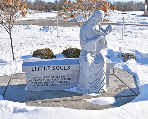 Within the cemetery of St. Mary Parish in Greensburg on Jan. 20, a statue of Jesus smiling and holding a baby marks the site of a section for burying miscarried babies called Little Souls Cemetery, a concept of Covenant Resources Miscarriage Ministry founded by Rebecca and Chris Harpring of St. Mary Parish. The couple&rsquo;s son Louis served as the model for the baby in the image, created by Michael McCarthy of St. John the Evangelist Parish in Indianapolis exclusively for the Harpring&rsquo;s use. (Photo by Natalie Hoefer)