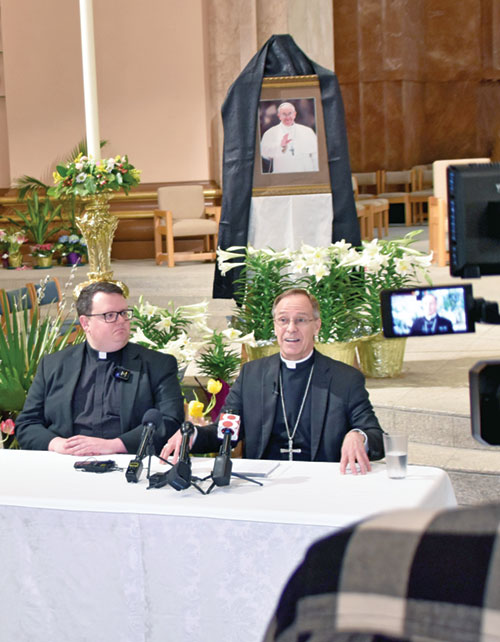 In SS. Peter and Paul Cathedral in Indianapolis on April 22, Archbishop Charles C. Thompson responds to a reporter&rsquo;s question during a press conference regarding the death of Pope Francis. At left is Father James Brockmeier, rector of the cathedral and director of the archdiocesan Office of Worship. (Photo by Natalie Hoefer)