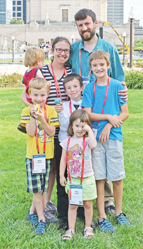 Leigh and Benjamin Sargeant and their five children&mdash;Rose in front, with Peter, left, Dominic and Samuel behind her, and Isaiah, held by Leigh&mdash;serve as an image of the family as a &ldquo;domestic Church&rdquo; as they pose in Memorial Plaza in Indianapolis on July 20, 2024, after adoration there during the National Eucharistic Congress. (File photo by Natalie Hoefer)