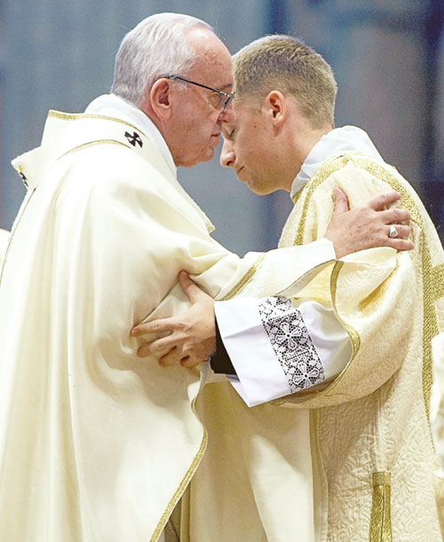 Pope Francis and then-transitional Deacon Anthony Hollowell exchange a sign of peace on March 19, 2016, during a Mass at St. Peter&rsquo;s Basilica at the Vatican. (Submitted photo)