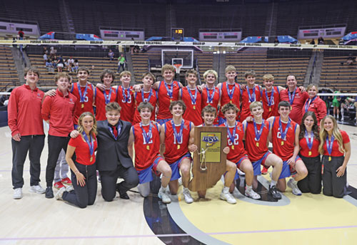The players, coaches and managers of the boys&rsquo; volleyball team of Roncalli High School in Indianapolis are all smiles on May 31 at Mackey Arena in West Lafayette, Ind., as they celebrate winning the first Indiana High School Athletic Association&rsquo;s state championship in the sport. (Photo courtesy of John Smith of Roncalli High School in Indianapolis)