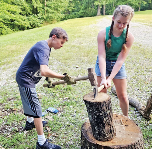 Jonas Burton, left, and Laila McMasters, both members of St. Agnes Parish in Nashville, work as a team to split wood for someone in need during St. Agnes&rsquo; Saints Training Camp, offered on June 25-29. (Submitted photo) 