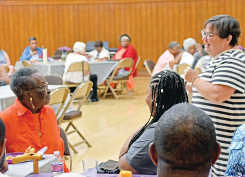 At a Senior Companion Program (SCP) volunteer gathering at the Archbishop Edward T. O&rsquo;Meara Catholic Center in Indianapolis on Aug. 6, Joyce Beaven, senior services director for Catholic Charities Indianapolis, right, offers words of gratitude to Alice Whitney, left, 94, for her 25 years volunteering with SCP. (Photo by Natalie Hoefer)