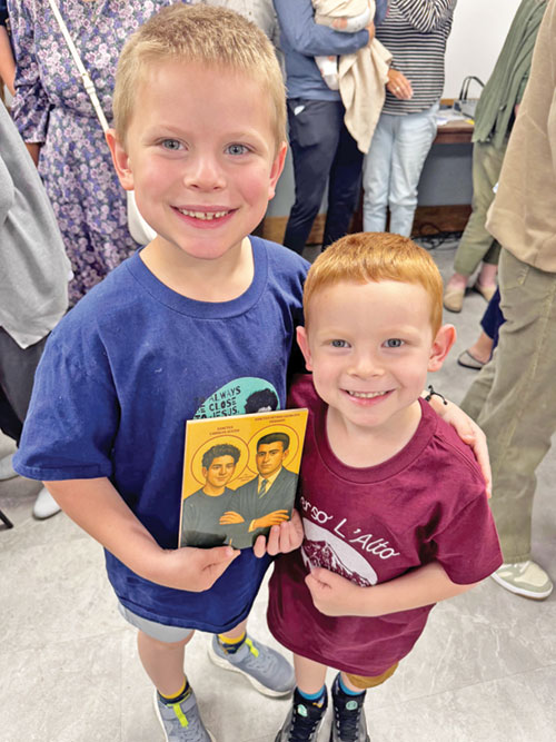 Leo Horine, 7, and his brother Isaac, 5, hold an image of St. Carlo Acutis and St. Pier Giorgio Frassati on Sept. 7 during a watch party held at St. John Paul II Parish in Sellersburg for the canonization of the Church&rsquo;s two newest saints. (Submitted photo)
