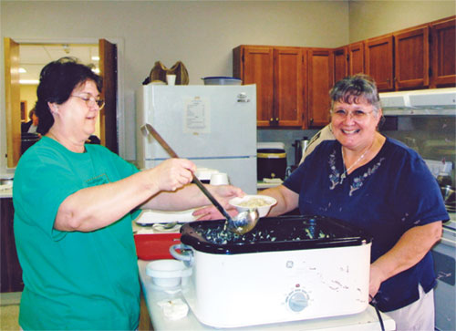 Serving up homemade chicken and noodles at the 2005 Rosary Society&nbsp;Craft Bazaar are, left to right, Joan Duncan and Dee Vincent. Vincent has been in charge of making the noodles for more than 25 years. (Submitted photo)