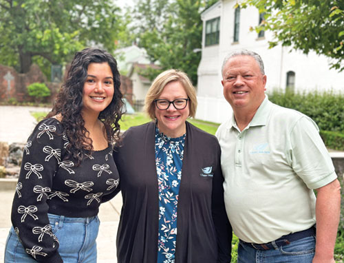 Dorcas Marrero, left, poses with Tricia Byrd, residential program director for St. Elizabeth Catholic Charities in New Albany, and agency director Mark Casper in the agency&rsquo;s Holy Trinity Park on May 30. (Photo courtesy of Cantaloupe)