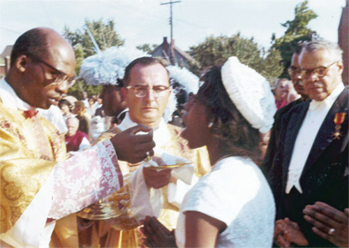 A woman receives holy Communion at an outdoor Mass held at St. Rita Church in Indianapolis on Aug. 4, 1963. The Mass was held as part of the 48th annual national convention of a Catholic fraternal order. Cardinal Laurean Rugambwa of Tanzania was the principal celebrant of the Mass, and the homily was given by then-Bishop Fulton J. Sheen, an auxiliary bishop of the Archdiocese of New York at the time. He will be beatified on Sept. 24.