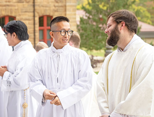 Deacon candidate Khaing Thu, center, smiles at transitional Deacon Gaten Armstrong of the Archdiocese of Mobile, Ala., on Oct. 25, 2025, outside the Archabbey Church of Our Lady of Einsiedeln in St. Meinrad prior to the Mass in which Thu was ordained a transitional deacon for the archdiocese. Deacon candidate Timothy Khuishing stands at left. (Photo courtesy of Saint Meinrad Archabbey)