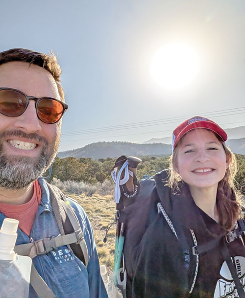 Rick Rush and his 14-year-old daughter Virginia flash smiles during the 50-mile pilgrimage they made to El Santuario de Chimayo in New Mexico, where a local resident in 1810 followed a light on Good Friday and discovered a 6-foot, wooden crucifix buried in a hillside, a discovery that eventually led to a small, adobe Catholic church to be built there. (Submitted photo)