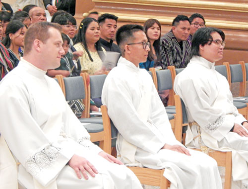 Transitional deacons Sam Hansen, left, Khaing Thu and Timothy Khuishing listen to Archbishop Charles C. Thompson&rsquo;s homily on June 6 at SS. Peter and Paul Cathedral in Indianapolis. The graduates of Roncalli High School in Indianapolis were ordained to the priesthood during the liturgy. (Photo by Mike Krokos)