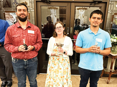 Guadalupe Godinez, right, smiles with Connor Roberts, left, and Megan Smith as they stand by the narthex doors in the back of St. Michael Church in Charlestown waiting to bring up the wine, bread and water during the Easter Vigil Mass on April 4. (Submitted photo by Jessica Sarver)