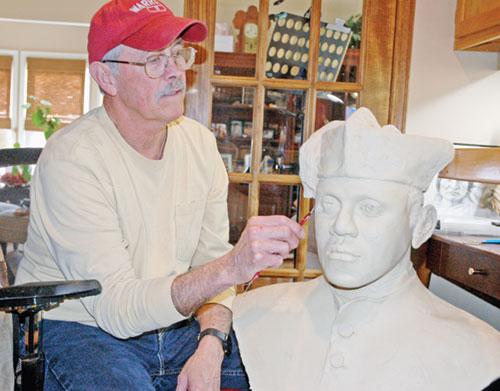 Forrest Tucker uses a sculpting knife to trim a clay bust of Venerable Augustus Tolton, the first recognized priest of African descent in the United States. (Photo by John Shaughnessy)