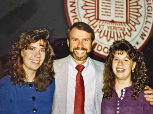 April Steber, left, and her sister Amy Miskuf pose for a photo with their father, Deacon David Reising. (Submitted photo) 