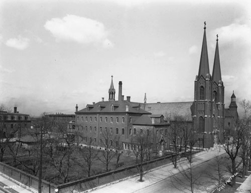An archive photo dating from 1928 shows the campus of Sacred Heart of Jesus Parish in Indianapolis. The 165-foot tall twin steeples continue today to dominate the skyline of the near southside of the city. (Used with permission from Indiana Album: Joan Hostetler Collection)