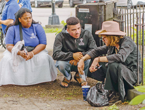 Cheyenne Johnson, a member of Our Lady of the Most Holy Rosary Parish in Indianapolis, and fellow perpetual pilgrim Marcel Ferrer, center, talk to a man during a stop on the National Eucharistic Pilgrimage. The journey of faith took place began on May 24 and ended in Philadelphia on the weekend of July 4. (Submitted photo)