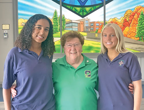 At 78, Providence Sister Mary Ann Stewart will soon begin another year of teaching U.S. History at Cathedral High School in Indianapolis&mdash;her 56th year of teaching in the archdiocese. Here she poses for a photo at the school with two seniors, Lauryn Klitzman, left, and Ella Battin, members of the National Honor Society. (Photo by John Shaughnessy)