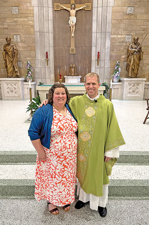 Megan Rust, parish catechetical leader for St. Paul Parish in Tell City, poses in the parish&rsquo;s church with the faith community&rsquo;s pastor Father Anthony Hollowell after he presented her the archdiocese&rsquo;s Archbishop Daniel Buechlein Excellence in Catechesis Award on Aug. 16. (Submitted photo by Brooke Greene) 