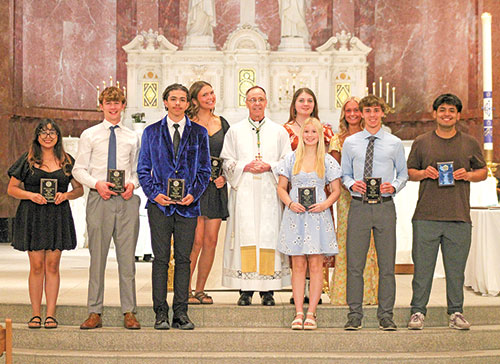 Archbishop Charles C. Thompson poses for a photo with recipients of the Bernie Price Spirit of Youth Award, named in honor of the longtime staff member of the archdiocese&rsquo;s Catholic Youth Organization. The youths were honored during the CYO&rsquo;s volunteer awards ceremony on May 12 at SS. Peter & Paul Cathedral in Indianapolis. (Photo courtesy of Zoe Hawkins)