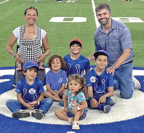 New archdiocesan chancellor Justin Reyes, right, and his wife Laura pose with their children on the Indianapolis Colts football field at Lucas Oil Stadium in Indianapolis on Aug. 22. Lily sits in front. Behind her are Giorgio, left, Joseph, Justin and Peter, and Laura holds 4-month-old Faustina. (Submitted photo)