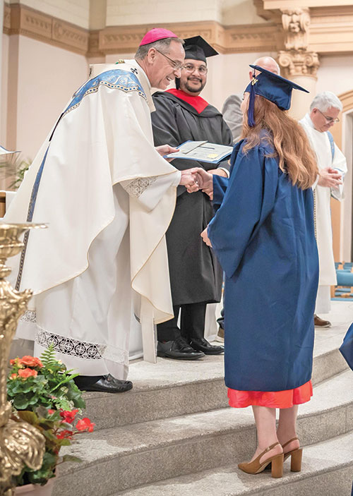 El arzobispo Charles C. Thompson felicita a Paholla Navarrete, de la parroquia de Nuestra Se&ntilde;ora del Sant&iacute;simo Rosario en Indian&aacute;polis, antes de entregarle un certificado que acredita su graduaci&oacute;n del Instituto de Pastoral Intercultural de la arquidi&oacute;cesis&mdash;un programa de dos a&ntilde;os de duraci&oacute;n&mdash;durante una ceremonia celebrada tras la misa en la Catedral de los Santos Pedro y Pablo de Indian&aacute;polis, el 21 de mayo. (Foto enviada)