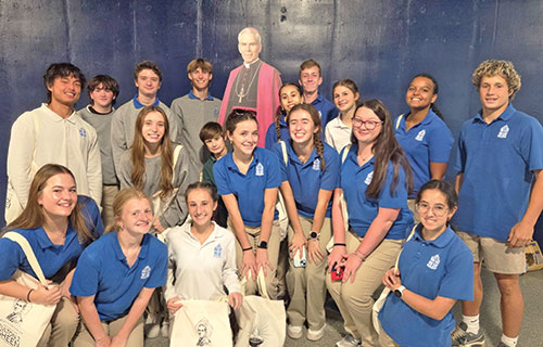 The students from Bishop Chatard High School in Indianapolis who attended the beatification Mass of Archbishop Fulton J. Sheen in St. Louis on Sept. 24 pose for a photo with a cardboard figure of Blessed Fulton. (Submitted photo)