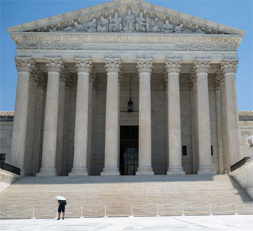 A person uses an umbrella to block the sun at the Supreme Court amid a heatwave in Washington on July 1. (OSV News photo/Annabelle Gordon, File Photo, Reuters)